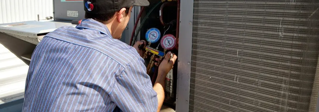 HVAC technician servicing a condenser unit in Lake Lorraine