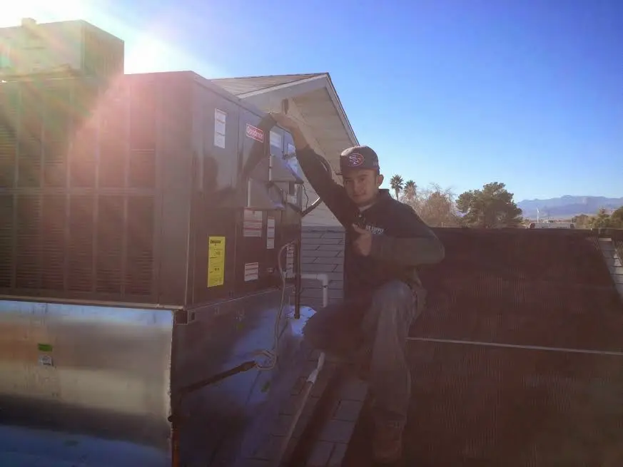 HVAC technician performing AC Tune-Up on a rooftop unit in Lake Lorraine